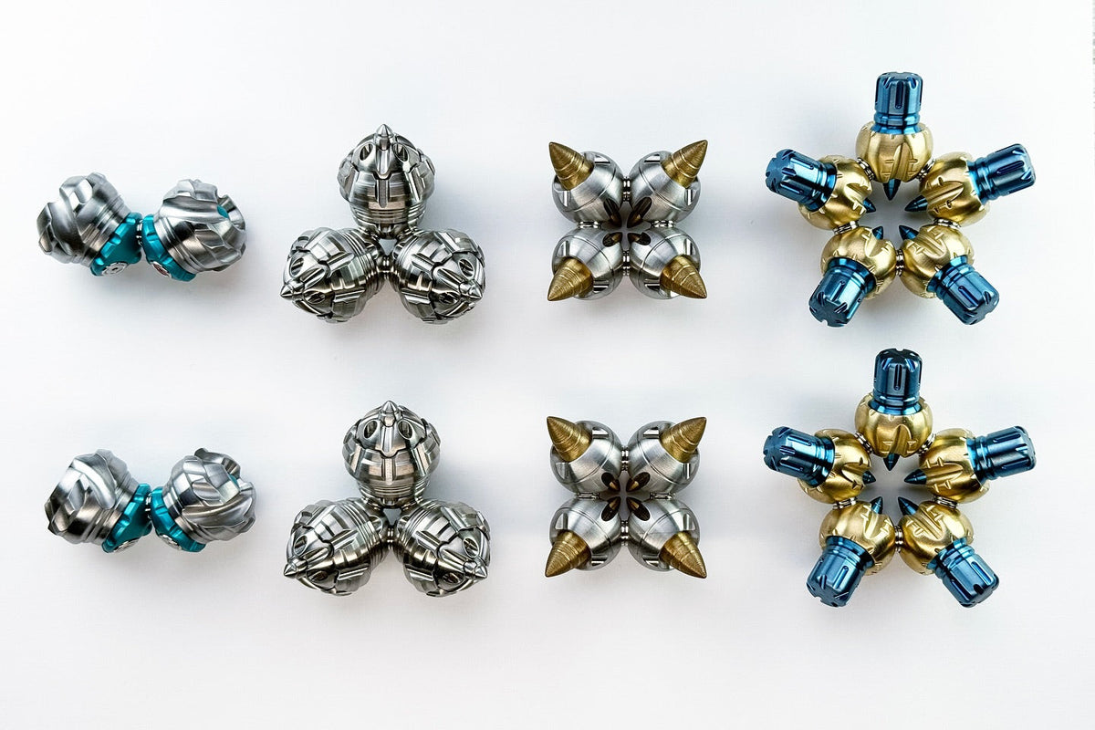 Two rows of small metal sculptures by Chris Bathgate on a white surface. Photo courtesy of Fablades.