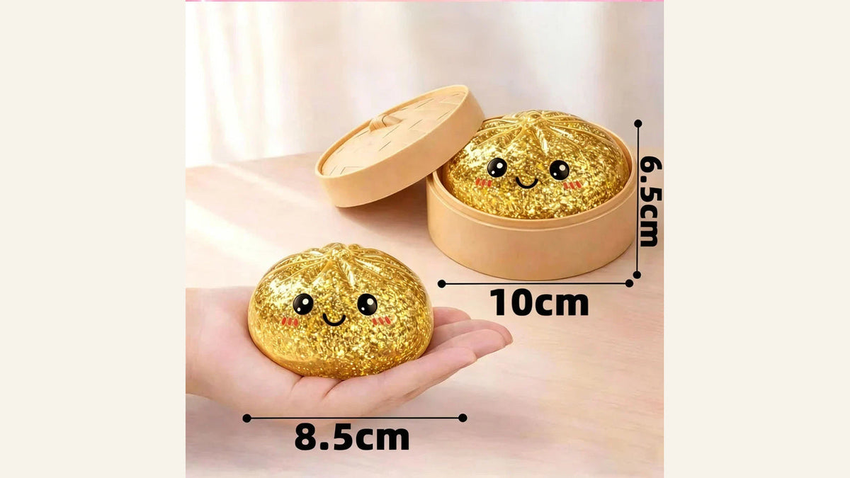Gold glitter dumpling-shaped squishy in a steamer-style container, with a hand-held example and supplier dimension labels.