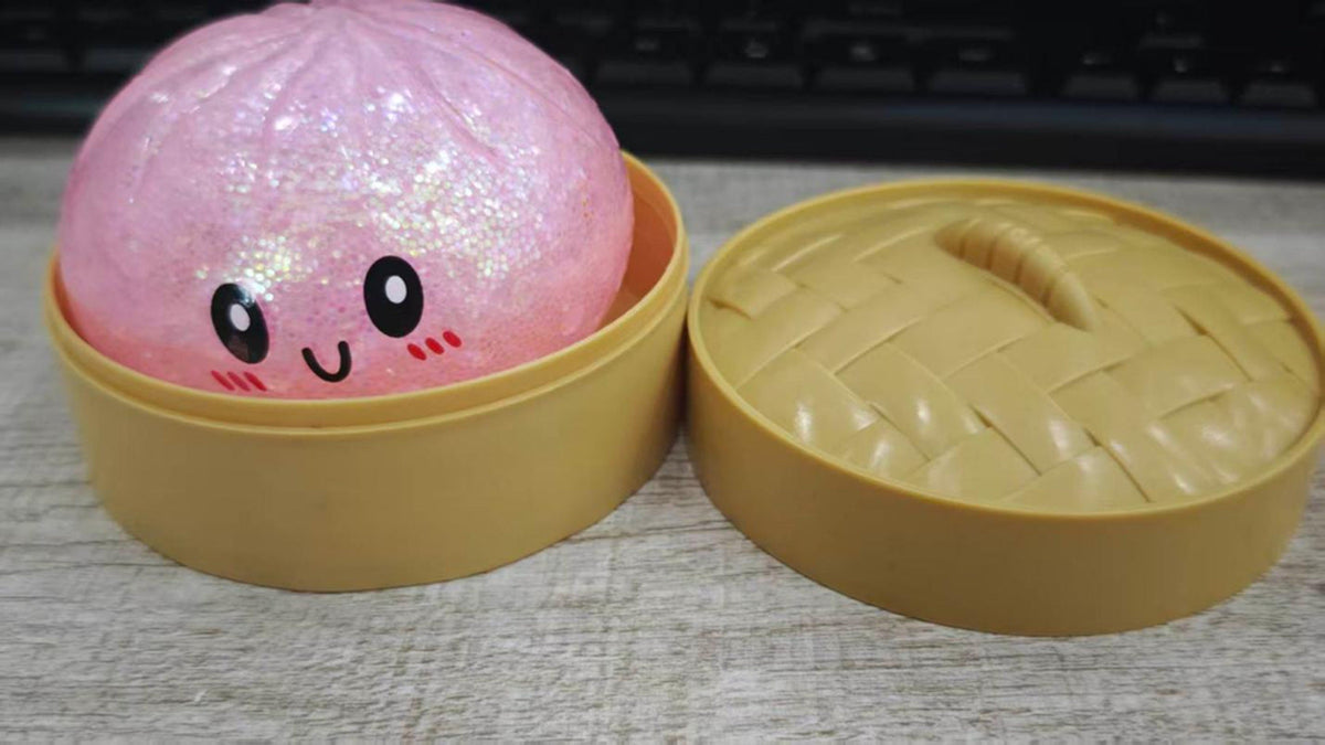 CPSC photo of the recalled pink GIHNJSI Squeezy Dumplings toy in its yellow steamer-style container.