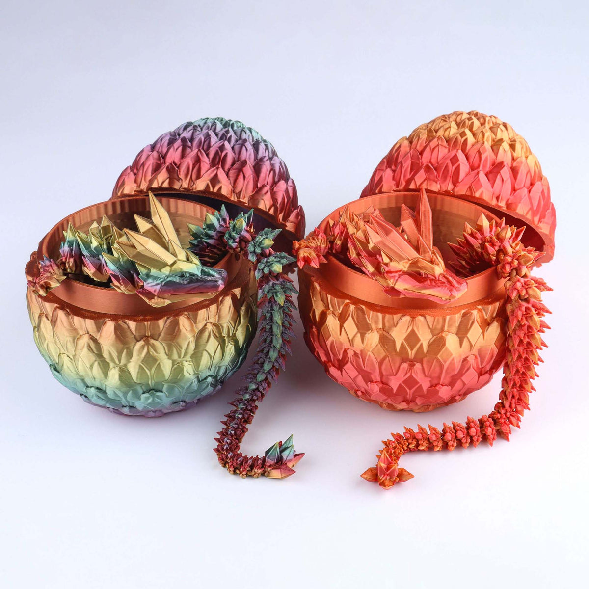 Two multicolored articulated dragons emerging from textured egg-shaped containers
