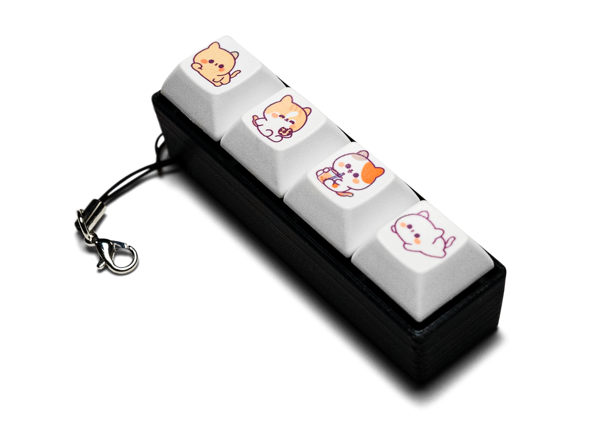Mechanical keycap fidget with four cat-design keys, a black base and a keychain clasp
